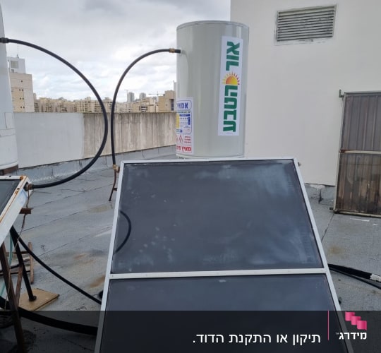 דוד שמש עם קולטים על גג תחת שמיים מעוננים